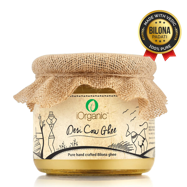 A jar of iOrganic A2 Desi Cow Ghee, made using the Ayurvedic bilona method from Sahiwal cow milk, displaying a rich, golden color with a granular texture, perfect for healthy cooking and improving overall wellness.
