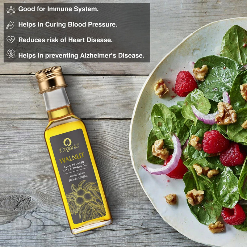 iOrganic Walnut Oil bottle next to a fresh salad with walnuts, highlighting its benefits for heart health, immune support, and cognitive function.