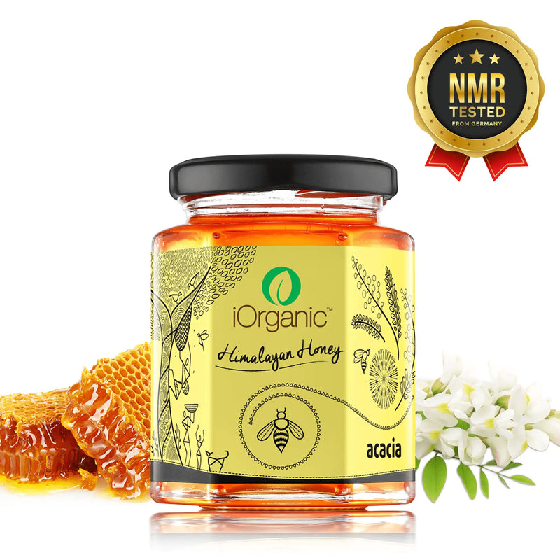 Jar of iOrganic Raw Acacia Honey from Kashmir Valley, NMR tested for purity, with a golden light color and clear acacia nectar source, displayed with honeycomb and flowers