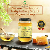 iOrganic Himalayan Acacia Honey jar with NMR tested seal, accompanied by a honey dipper and honeycomb, inviting to 'Discover The Taste of Purity in Every Drop of iOrganic Honey.