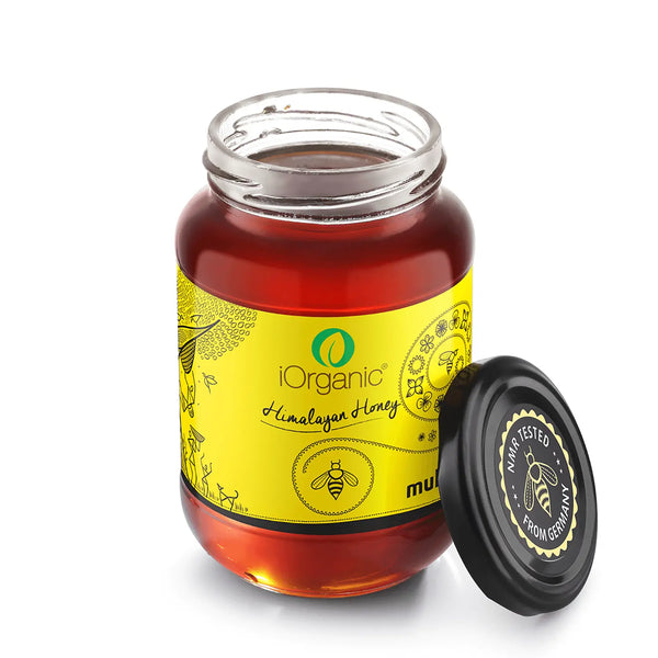 iOrganic Raw Himalayan Multi-floral Unfiltered Honey jar opened, revealing the dark amber color, certified by NMR testing for purity, embodying the best of organic raw honey